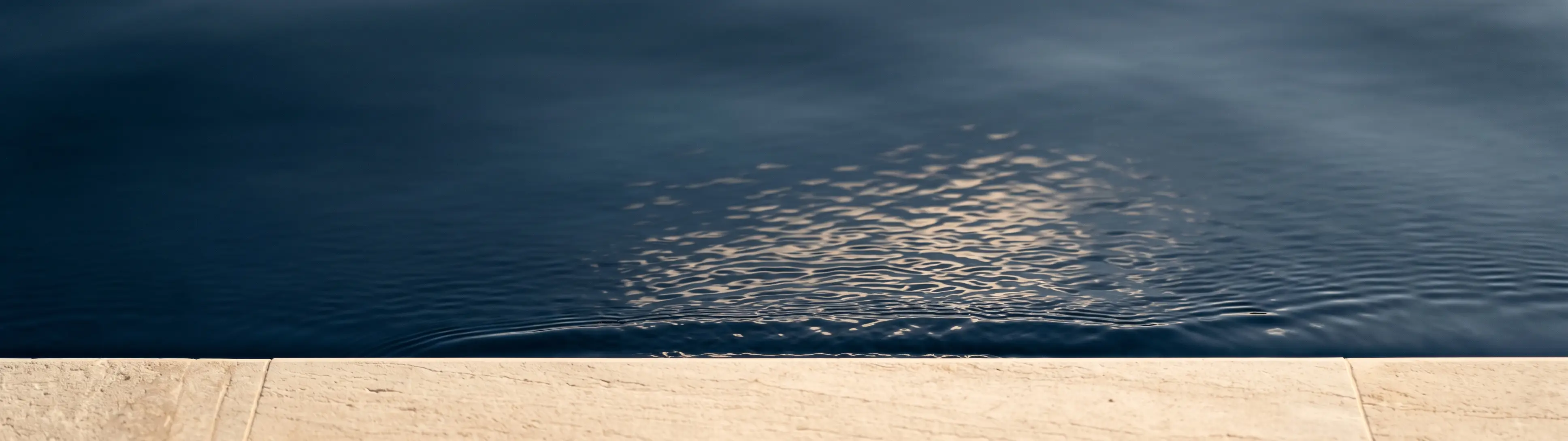 A single fine line curving across a pale textured surface