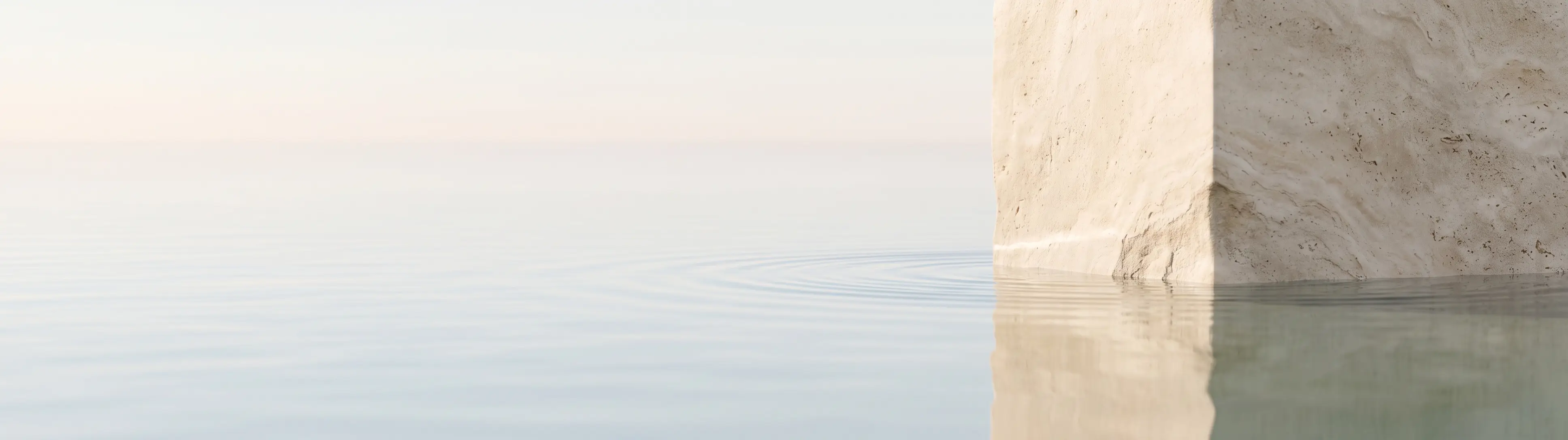 Open sea meeting a pale stone edge under soft light