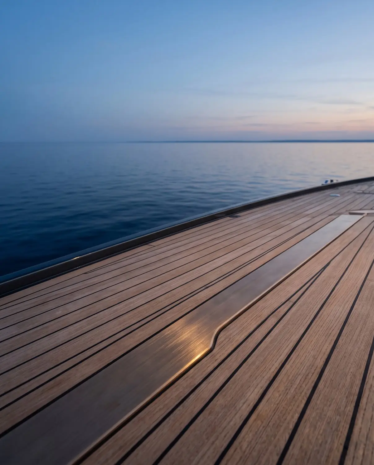 Superyacht deck detail at dusk with a calm open horizon beyond