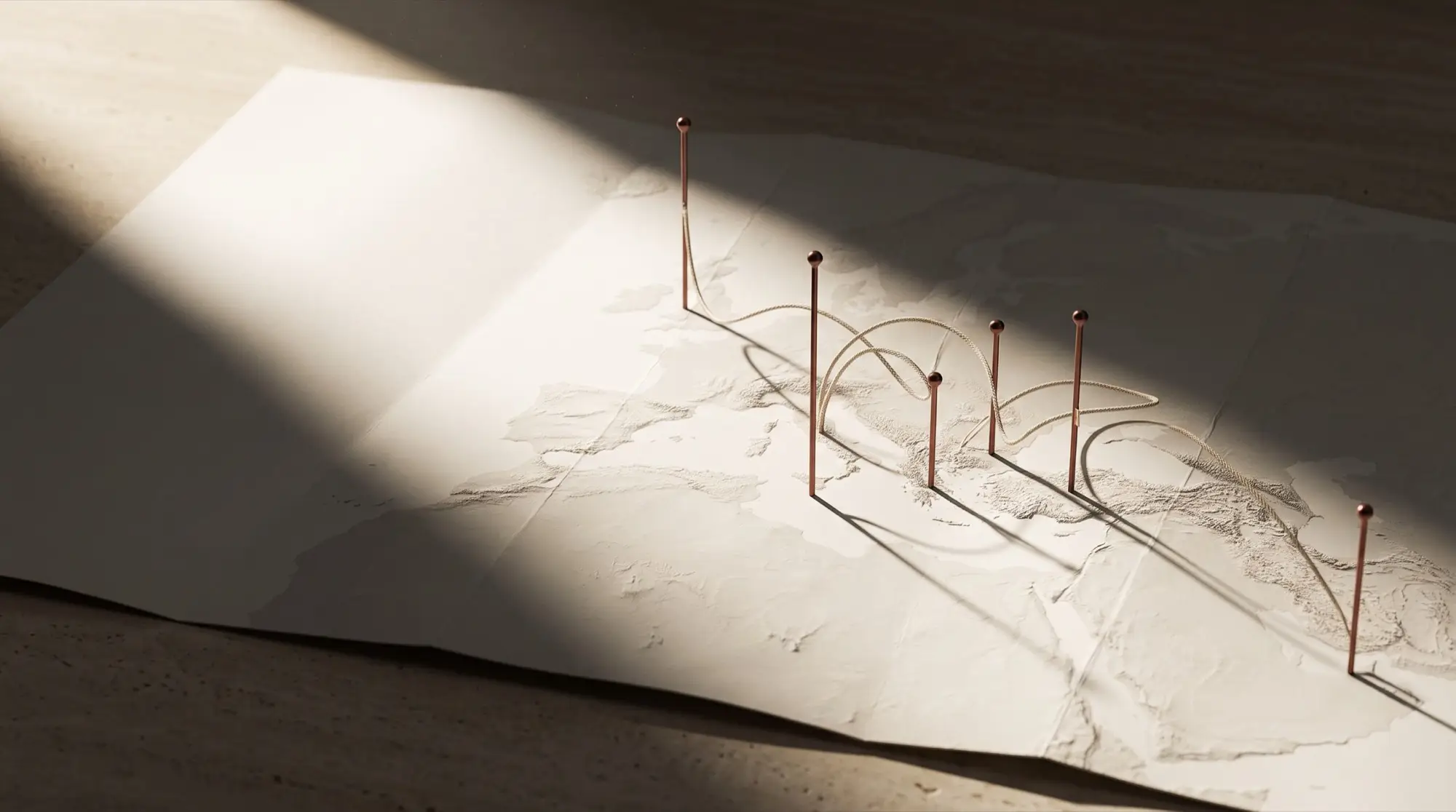 Folded relief map with slender brass markers and connecting arcs