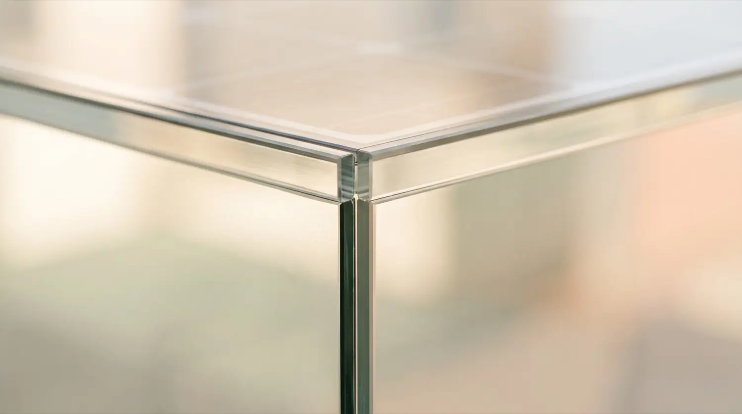 Light passing through the edge of a clear glass form on a pale surface